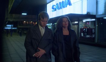 Movie still from “A Short Film About Love” (1988), directed by Krzysztof Kieslowski – A man and a woman are standing in front of a building; Medium shot, Low angle