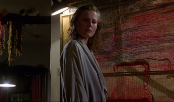 Movie still from “A Short Film About Love” (1988), directed by Krzysztof Kieslowski – A woman standing in front of a painting; Medium shot, Low angle