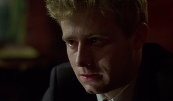 Movie still from “A Short Film About Love” (1988), directed by Krzysztof Kieslowski – A person wearing a suit and tie; Close Up shot, Low angle