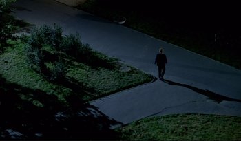 Movie still from “A Short Film About Love” (1988), directed by Krzysztof Kieslowski – A man walking down a sidewalk at night; Extreme Wide shot, High angle