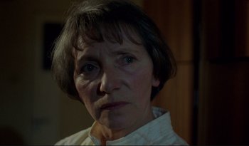 Movie still from “A Short Film About Love” (1988), directed by Krzysztof Kieslowski – An older woman is looking at the camera; Close Up shot, Over the shoulder angle