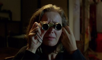 Movie still from “A Short Film About Love” (1988), directed by Krzysztof Kieslowski – A woman holding a pair of binoculars up to her face; Close Up shot, Over the shoulder angle