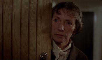 Movie still from “A Short Film About Love” (1988), directed by Krzysztof Kieslowski – An older woman standing in front of a wooden door; Close Up shot, Over the shoulder angle