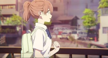 A woman with a ponytail and a white shirt is looking out a window