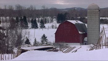 Movie still from “A Simple Plan” (1998), directed by Sam Raimi – A red barn sitting on top of a snow covered field; Extreme Wide shot, High angle