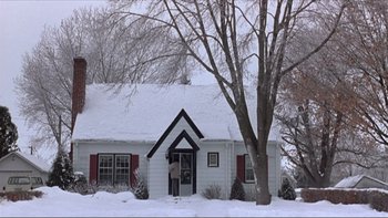 Movie still from “A Simple Plan” (1998), directed by Sam Raimi – A white house with snow on the roof and trees in the background; Extreme Wide shot, Low angle