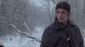 Movie still from “A Simple Plan” (1998), directed by Sam Raimi – A man standing in the snow near a tree; Close Up shot, Over the shoulder angle