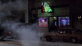 Movie still from “A Simple Plan” (1998), directed by Sam Raimi – Smoke billows out of a building on a snowy night; Wide shot, High angle