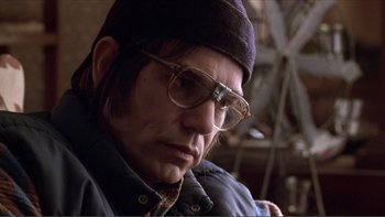 Movie still from “A Simple Plan” (1998), directed by Sam Raimi – A man wearing glasses and a hat looking at the camera; Close Up shot, Low angle