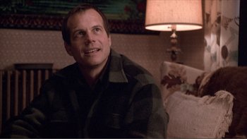 Movie still from “A Simple Plan” (1998), directed by Sam Raimi – A man sitting in front of a lamp in a living room; Close Up shot, Over the shoulder angle