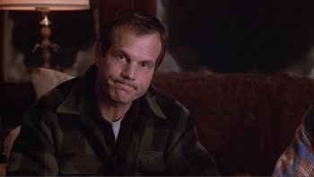 Movie still from “A Simple Plan” (1998), directed by Sam Raimi – A person sitting on a couch in a living room; Close Up shot, High angle