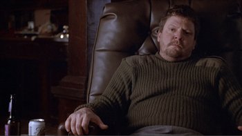 Movie still from “A Simple Plan” (1998), directed by Sam Raimi – A person sitting in a chair; Medium shot, High angle