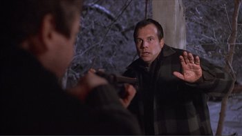 Movie still from “A Simple Plan” (1998), directed by Sam Raimi – A man holding a gun in front of another man; Medium shot, Over the shoulder angle