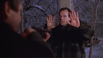 Movie still from “A Simple Plan” (1998), directed by Sam Raimi – A man holding his hands up in front of another man; Medium shot, Over the shoulder angle