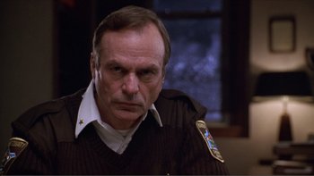 Movie still from “A Simple Plan” (1998), directed by Sam Raimi – An older man wearing a brown jacket and a white shirt; Close Up shot, Low angle