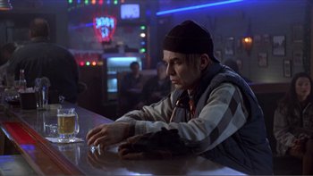 Movie still from “A Simple Plan” (1998), directed by Sam Raimi – A man sitting at a bar with a glass of beer in front of him; Medium shot, Over the shoulder angle