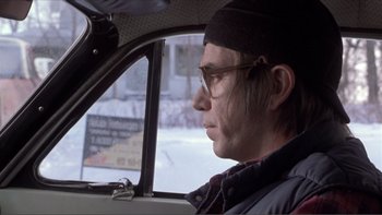 Movie still from “A Simple Plan” (1998), directed by Sam Raimi – A man sitting in the passenger seat of a car looking out the window; Close Up shot, Low angle