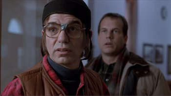 Movie still from “A Simple Plan” (1998), directed by Sam Raimi – A man wearing glasses and a hat standing next to another man; Close Up shot, Over the shoulder angle