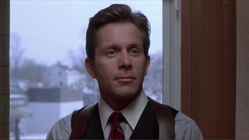 Movie still from “A Simple Plan” (1998), directed by Sam Raimi – A person wearing a suit and tie; Close Up shot, Low angle