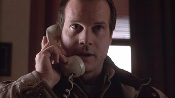 Movie still from “A Simple Plan” (1998), directed by Sam Raimi – A man holding a phone up to his ear; Close Up shot, Low angle