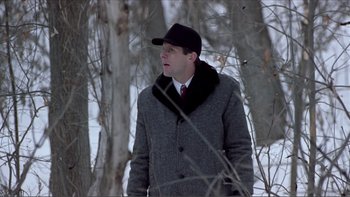 Movie still from “A Simple Plan” (1998), directed by Sam Raimi – A man wearing a hat and a coat walking in the snow; Medium shot, Low angle