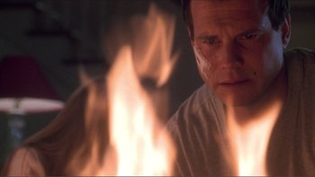 Movie still from “A Simple Plan” (1998), directed by Sam Raimi – A man is sitting in front of a fire; Close Up shot, Low angle