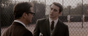 Movie still from “A Single Man” (2009), directed by Tom Ford – A man in a suit talking to another man in a suit; Medium shot, Over the shoulder angle