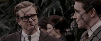 Movie still from “A Single Man” (2009), directed by Tom Ford – A man wearing a suit and tie standing next to a fence; Close Up shot, Over the shoulder angle