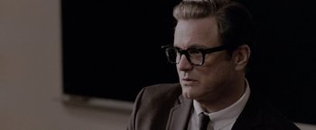Movie still from “A Single Man” (2009), directed by Tom Ford – A person wearing glasses and a suit; Close Up shot, Over the shoulder angle