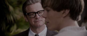 Movie still from “A Single Man” (2009), directed by Tom Ford – A man in a suit and glasses talking to another man in a suit and glasses; Close Up shot, Over the shoulder angle