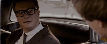 Movie still from “A Single Man” (2009), directed by Tom Ford – A man wearing a suit and glasses sitting in a car; Close Up shot, Over the shoulder angle
