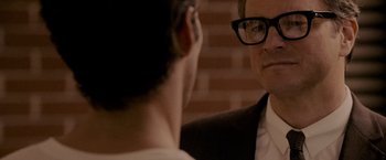 Movie still from “A Single Man” (2009), directed by Tom Ford – A man in a suit and glasses talking to another man in a suit; Close Up shot, Over the shoulder angle