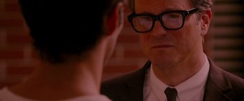 Movie still from “A Single Man” (2009), directed by Tom Ford – A man in a suit and glasses looking at his reflection in a mirror; Close Up shot, Over the shoulder angle