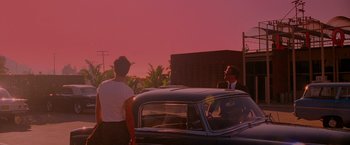 Movie still from “A Single Man” (2009), directed by Tom Ford – Two men standing in front of a car at sunset; Extreme Wide shot, Over the shoulder angle