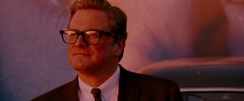 Movie still from “A Single Man” (2009), directed by Tom Ford – A person wearing glasses and a suit; Close Up shot, Low angle