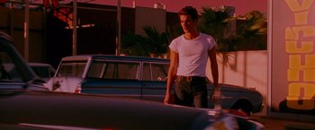 Movie still from “A Single Man” (2009), directed by Tom Ford – A man standing in front of a blue car; Medium shot, Low angle