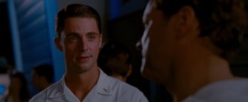 Movie still from “A Single Man” (2009), directed by Tom Ford – A man in a white shirt is talking to another man; Close Up shot, Over the shoulder angle