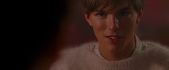 Movie still from “A Single Man” (2009), directed by Tom Ford – A person wearing a white sweater; Close Up shot, Over the shoulder angle