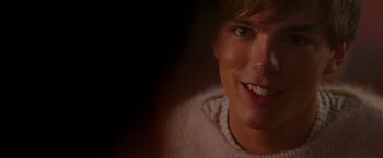 Movie still from “A Single Man” (2009), directed by Tom Ford – A person smiling for the camera; Close Up shot, Over the shoulder angle