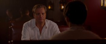 Movie still from “A Single Man” (2009), directed by Tom Ford – A man sitting in front of another man in a restaurant; Medium shot, Over the shoulder angle