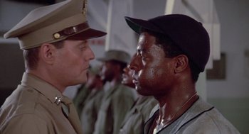 Movie still from “A Soldier's Story” (1984), directed by Norman Jewison – Two men in uniform talking to each other in front of a group of men; Close Up shot, Over the shoulder angle