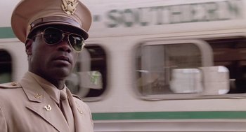 Movie still from “A Soldier's Story” (1984), directed by Norman Jewison – A man in a uniform is standing in front of a train; Close Up shot, Low angle