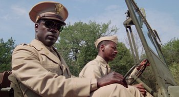 Movie still from “A Soldier's Story” (1984), directed by Norman Jewison – Two men in military uniforms sitting in the back of a truck; Medium shot, Low angle