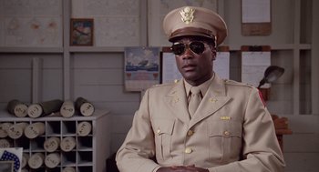 Movie still from “A Soldier's Story” (1984), directed by Norman Jewison – A man in a military uniform wearing sunglasses; Medium shot, Low angle