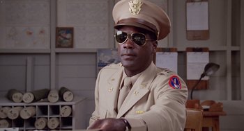 Movie still from “A Soldier's Story” (1984), directed by Norman Jewison – A man in a military uniform wearing sunglasses; Medium shot, Low angle