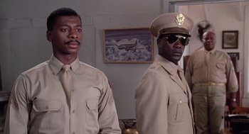 Movie still from “A Soldier's Story” (1984), directed by Norman Jewison – A couple of men standing next to each other in uniform; Medium shot, Low angle