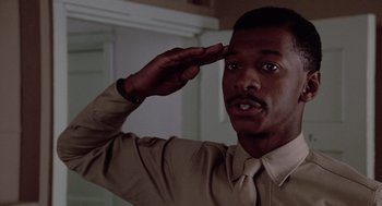 Movie still from “A Soldier's Story” (1984), directed by Norman Jewison – A man saluting with his hand on top of his head; Close Up shot, Low angle