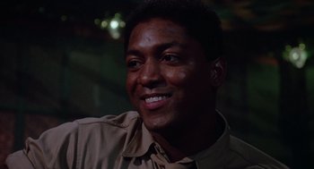 Movie still from “A Soldier's Story” (1984), directed by Norman Jewison – A person smiling at the camera; Close Up shot, Low angle