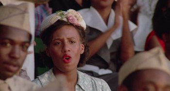 Movie still from “A Soldier's Story” (1984), directed by Norman Jewison – A woman with a flower in her hair is making a funny face; Close Up shot, Low angle