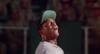 Movie still from “A Soldier's Story” (1984), directed by Norman Jewison – A man in a baseball cap looking up at the sky; Close Up shot, Low angle